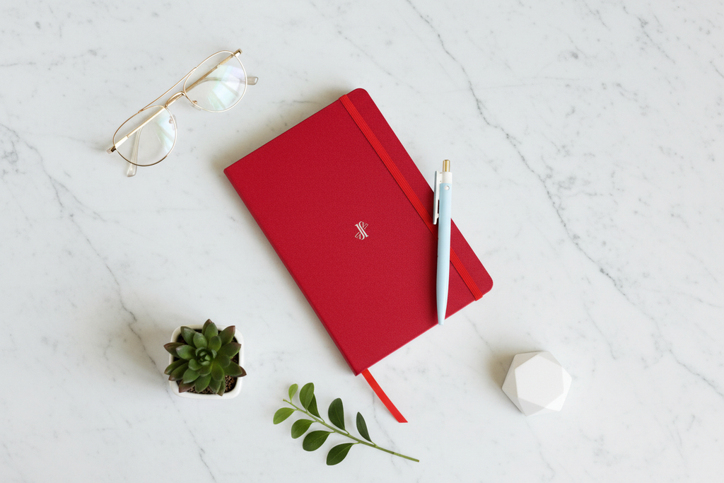 Flat lay cuaderno rojo JVJ Brand